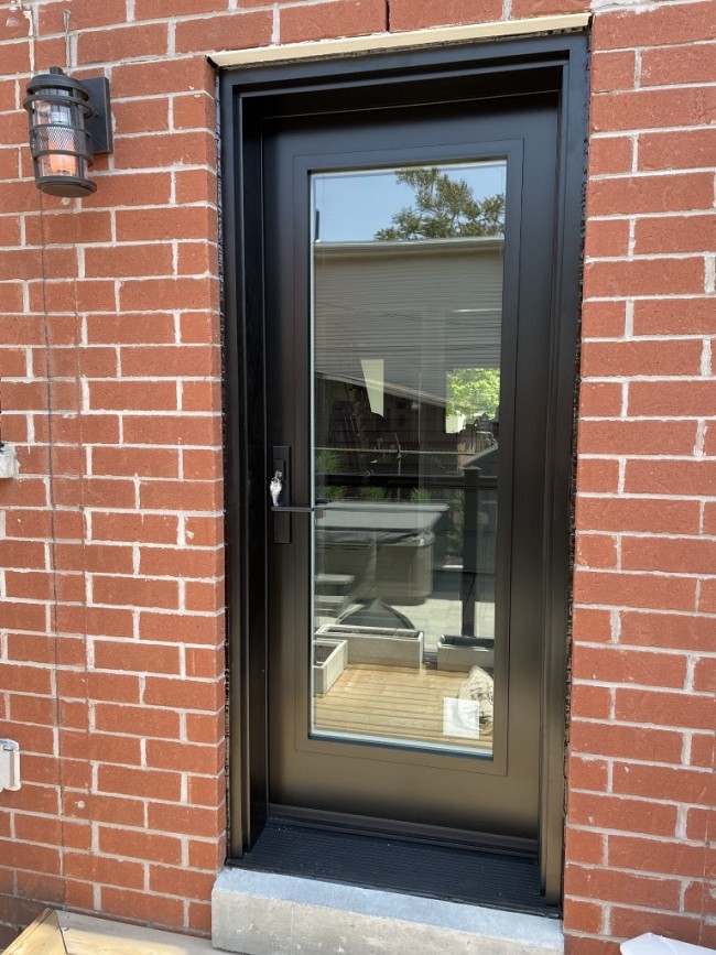 black rear entry door on brick home